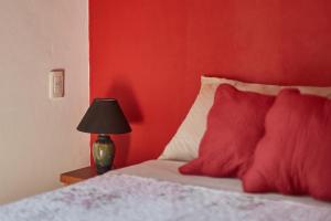 1 dormitorio rojo con 1 cama con pared roja en Elén, en Punta del Diablo