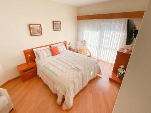 a bedroom with a bed and a television in it at Ofir Beach Flat in Esposende
