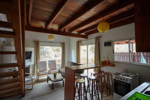 a kitchen with a counter and a bar with stools at Elén in Punta Del Diablo