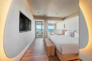 a hotel room with a bed and a television at The Views Baia - Adults Only in Funchal