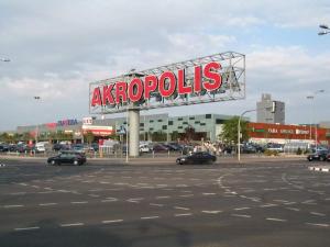 a large sign for aazoptolis in a parking lot at Apartamentai su balkonu prie Akropolio Taikos pr 48 in Klaipėda