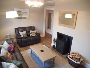 uma sala de estar com um sofá e uma lareira em East Cottage at Parbroath Farm em Cupar