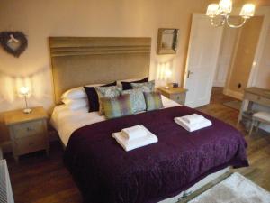 um quarto com uma cama grande com duas toalhas em East Cottage at Parbroath Farm em Cupar