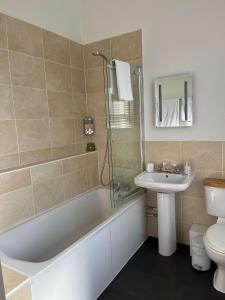 a bathroom with a tub and a sink and a toilet at Hotel 50 in Bournemouth