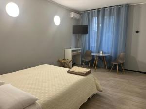 1 dormitorio con 1 cama y 1 mesa con sillas en FlatMILAN, en Cernusco sul Naviglio