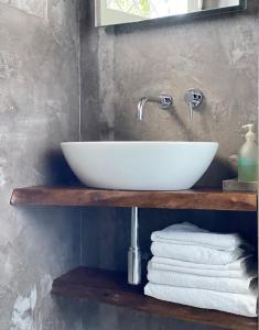 a bathroom sink on a wooden shelf with towels at B&B Panorama Cinque in Salò