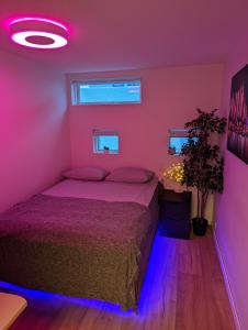 Un dormitorio con una cama con luces moradas. en Smart Luxury - Gaming Arena, Gym, Sauna and Jacuzzi en Keflavík