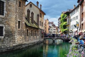 Un groupe de personnes marchant au-dessus d'un pont sur une rivière dans l'établissement le FAMILY LODGE 2 chambres 4 personnes classe 3 etoiles, à Annecy