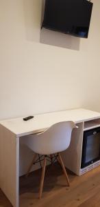 a white desk with a chair and a television on top at Garni San Lorenzo in Pinzolo