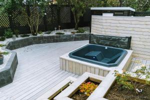 a hot tub sitting on top of a wooden deck at Smart Luxury - Private Gym, Hot Tub & Sauna in Keflavík