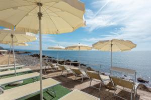 a group of chairs and umbrellas on a beach at Hotel Cavalluccio Marino in Santa Marinella