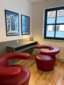 a waiting room with three red stools in a room at Double B in Erfurt