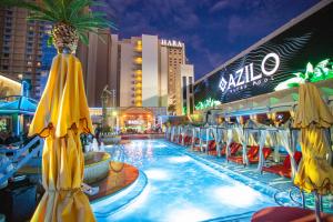 a pool at a resort with yellow umbrellas at SAHARA Las Vegas in Las Vegas