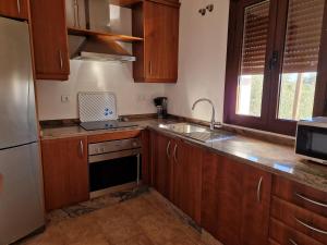 kuchnia z drewnianymi szafkami, zlewem i lodówką w obiekcie Casa Rural La Era 3 - Adults Only w mieście Aracena