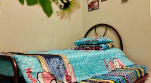 ein Bett mit einer Decke und Kissen darauf in der Unterkunft Faridah Homestay Melaka Muslim Friendly in Kampong Bukit Katil