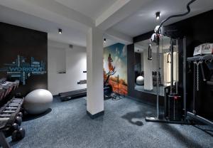 Bijele Vode spa&nature hotel في برييدور: صالة لياقة مع صالة رياضية مع جهاز ركض