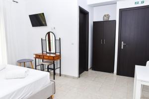 a bedroom with two beds and a table and a mirror at Donna Dorato in Finikounta