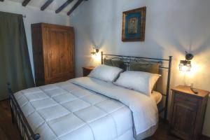 1 dormitorio con cama blanca y armario de madera en La Finestra su Civita, en Lubriano