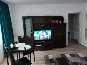 a living room with a television and a dining room table at Apartament în Buzău in Buzau