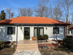 a small white house with an orange roof at Agroger Üdülő in Balatonudvari