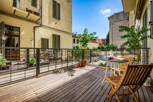 a wooden deck with a table and chairs on a balcony at Luxury apt in the heart of city out of ZTL in Florence