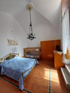 a bedroom with a bed and a chandelier at Casa Muse in Maiori