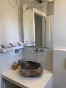 波多河麗的住宿－Mimozas Apartment Porto Heli，一间带石制水槽和镜子的浴室