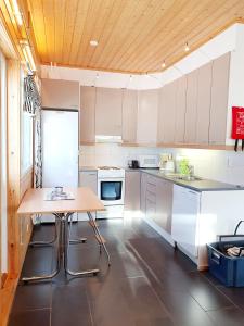 eine Küche mit weißen Schränken und einer Holzdecke in der Unterkunft Saunatupa in Syöte