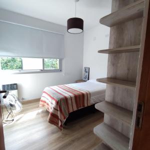 1 dormitorio con 1 cama con manta a rayas en Casa en Solares del Carcaraña en Oliveros