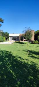 un gran campo de hierba con un edificio en el fondo en Casa en Solares del Carcaraña en Oliveros