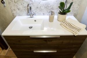 a white sink in a bathroom with a potted plant at La Finestra su Civita in Lubriano