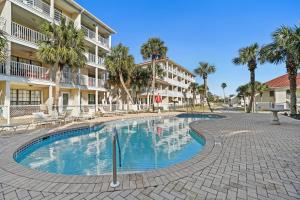 una piscina frente a un edificio con palmeras en Horizon South by Panhandle Getaways, en Panama City Beach