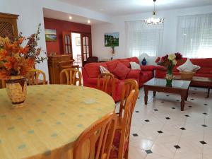 sala de estar con mesa y sofá rojo en CASA RURAL EL ROCINANTE, en Miguel Esteban