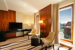 a hotel room with a desk and a large window at Hotel Fahrenheit in Gdańsk