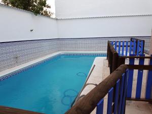 a swimming pool with a bench next to a fence at CASA RURAL EL ROCINANTE in Miguel Esteban