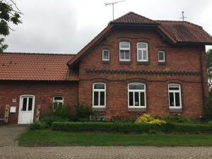 uma casa de tijolos com janelas brancas e uma porta branca em Privatquartier van Dreuten em Warpe