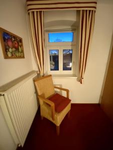 uma cadeira sentada num quarto com uma janela em Privatquartier van Dreuten em Warpe