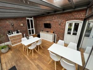 a room with white tables and chairs and a brick wall at Privatquartier van Dreuten in Warpe