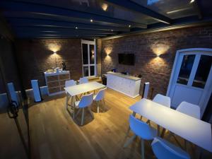 uma sala de jantar com mesas e cadeiras brancas em Privatquartier van Dreuten em Warpe