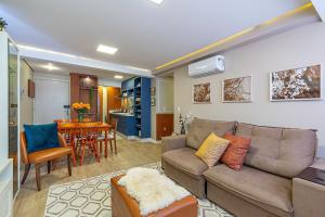 a living room with a couch and a dining room at Café da Banca - Stay House Temporada in Gramado