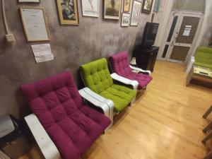 three different colored chairs sitting in a room at Rooster Hostel in Veliko Tŭrnovo