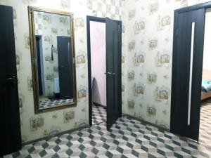 ein Badezimmer mit zwei Spiegeln und einem Schachbrettmusterboden in der Unterkunft comfortable apartment in Chişinău