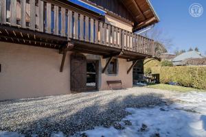 eine Veranda eines Hauses mit Schnee auf dem Boden in der Unterkunft Gite cosy en montagne avec vue et piscine in Marthod