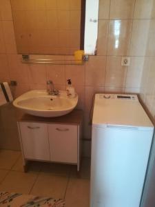 a bathroom with a sink and a small refrigerator at Apartments Martinac in Sukošan