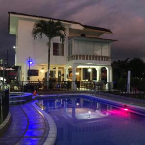 a swimming pool in front of a house at night at Finca Hotel San Angello in Quimbaya