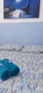 a bed with two blue pillows on top of it at Pousada Fortaleza in Fortaleza