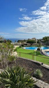 a view of a resort with a swimming pool and the ocean at La Maison Amarilla Golf in San Miguel de Abona