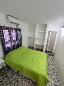 a bedroom with a green bed in a room at Departamento zona centro , Catamarca in San Fernando del Valle de Catamarca