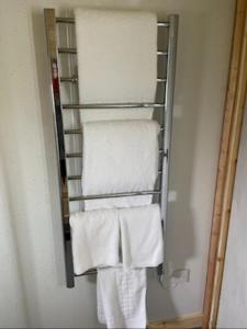 a towel rack in a bathroom with white towels at Badger's Sett in Bathgate