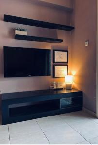 a living room with a large television and a lamp at Mermaid Holiday Apartments in Mandria
